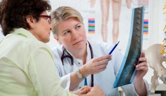ένας γιατρός εξετάζει μια ακτινογραφία για πόνο στην πλάτη